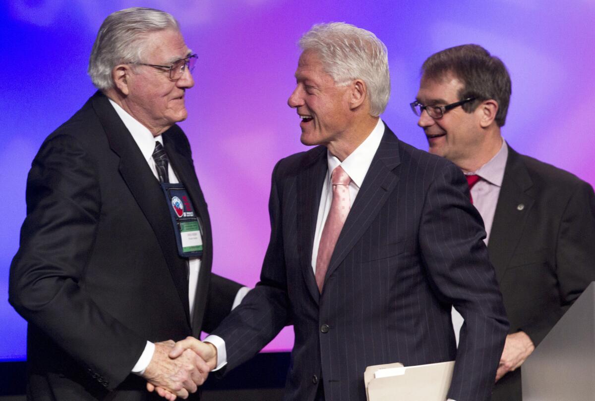 Former President Bill Clinton shakes hands with Owen Bieber, left, as UAW President Bob King looks on at the 2012 UAW National Community Action Program Conference in Washington in 2012.
