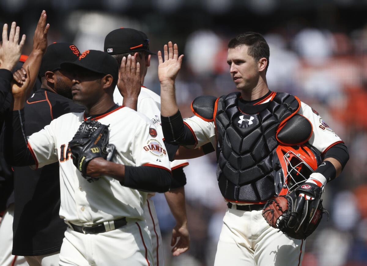 Giants catcher Buster Posey celebrates with teammates after sweeping the Dodgers with three consecutive shutouts.