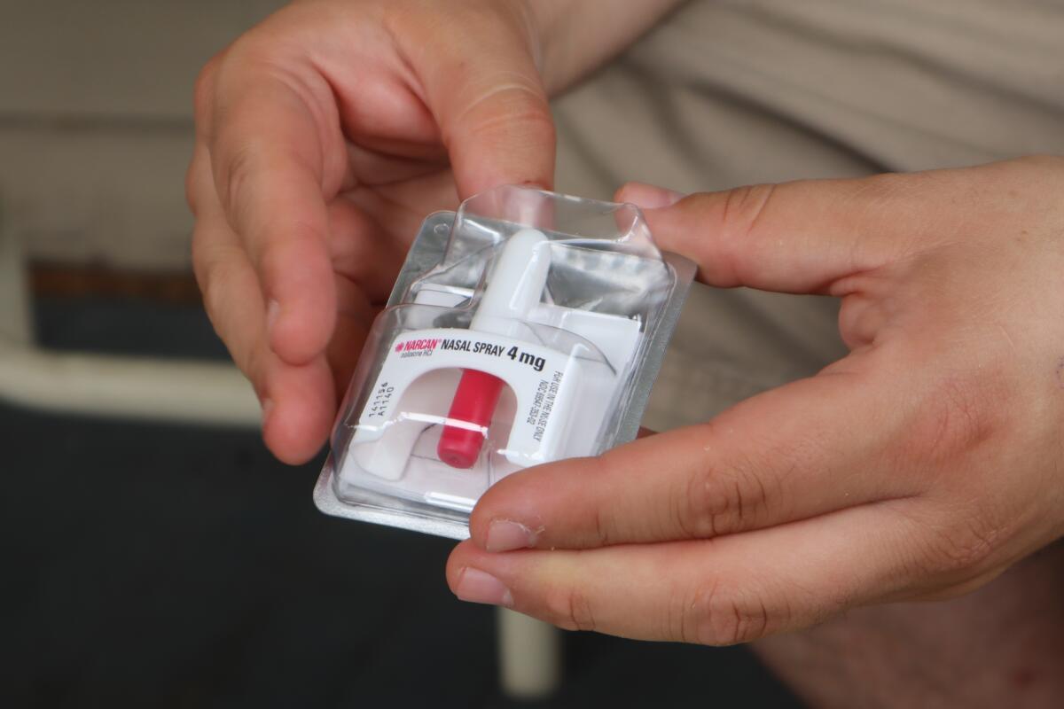 A man holds a dose of the opioid overdose reversal medication Narcan in his hands.
