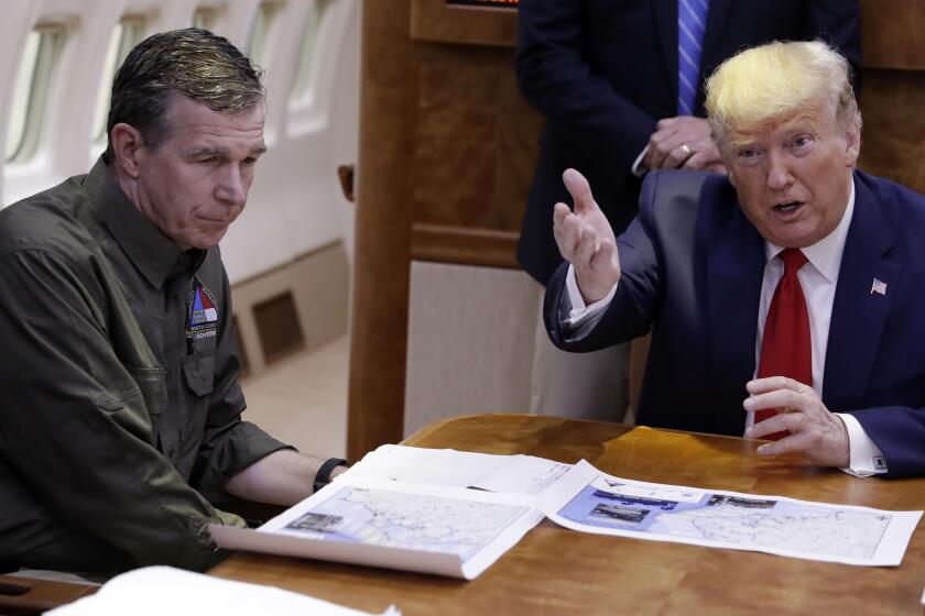 FILE - In this Sept. 9, 2019, file photo, President Donald Trump participates in a briefing about Hurricane Dorian with North Carolina Gov. Roy Cooper, left, aboard Air Force One at Marine Corps Air Station Cherry Point in Havelock, N.C. President Donald Trump demanded Monday, May 25, 2020, that North Carolina's Democratic governor sign off “immediately” on allowing the Republican National Convention to move forward in August with full attendance despite the ongoing COVID-19 pandemic. Trump's tweets Monday about the RNC, planned for Charlotte, come just two days after the North Carolina recorded its largest daily increase in positive cases yet.(AP Photo/Evan Vucci)