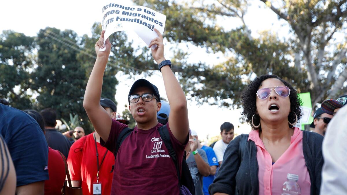 Bryan Peña, 18, of Los Angeles, a freshman at Cal State L.A., and his former teacher Peta Lindsay of the Los Angeles Leadership Academy join a protest against the phasing out of protections for young immigrants in the U.S. illegally.