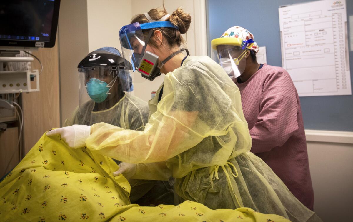 Nurses in the Intensive Care Unit at Martin Luther King, Jr., Community Hospital attend to a patient with COVID-19. 