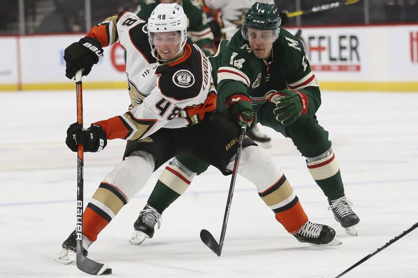 Anaheim Ducks' Isac Lundestrom (48) controls the puck against Minnesota Wild's Joel Eriksson Ek of Sweden (14) during the second period of an NHL hockey game Monday, March 22, 2021, in St. Paul, Minn. (AP Photo/Stacy Bengs)