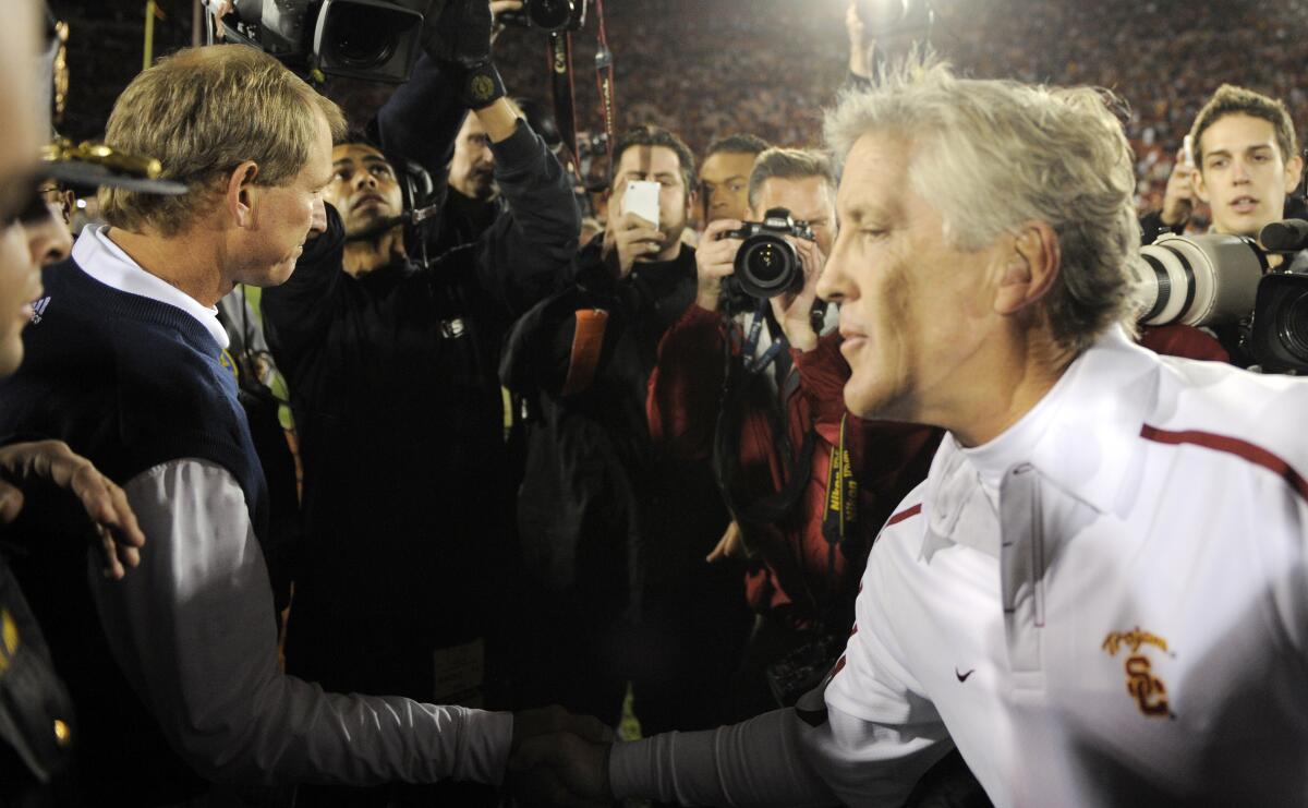 USC coach Pete Carroll speaks as he shakes hands with UCLA coach Rick Neuheisel following the Trojans' 28-7 victory in 2009.