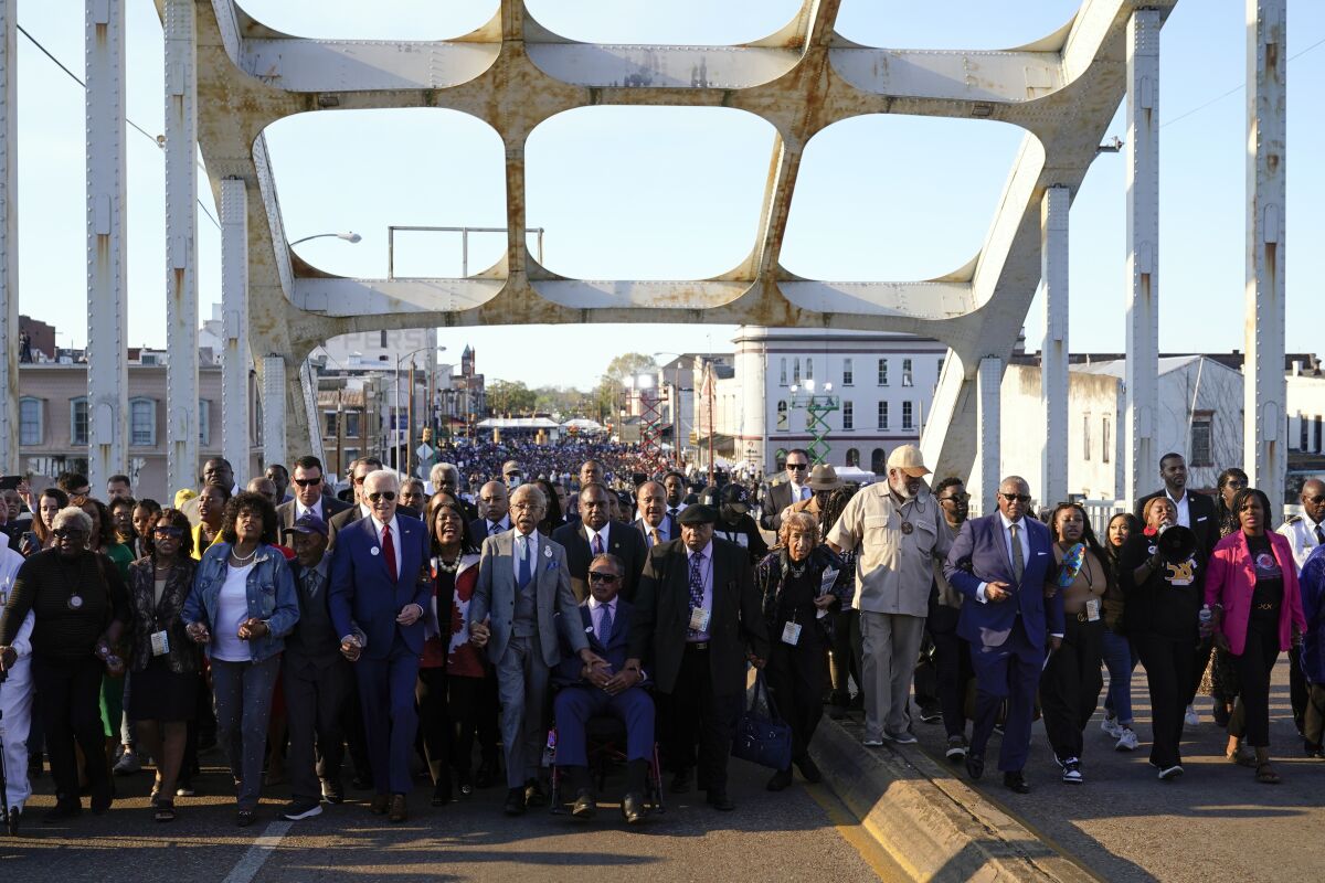 President Biden walks with a group across the Edmund Pettus Bridge in Selma, Ala