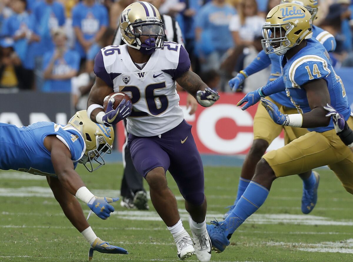 Washington running back Salvon Ahmed runs into the UCLA defensive backfield for a long gain in the first quarter on Saturday at the Rose Bowl.