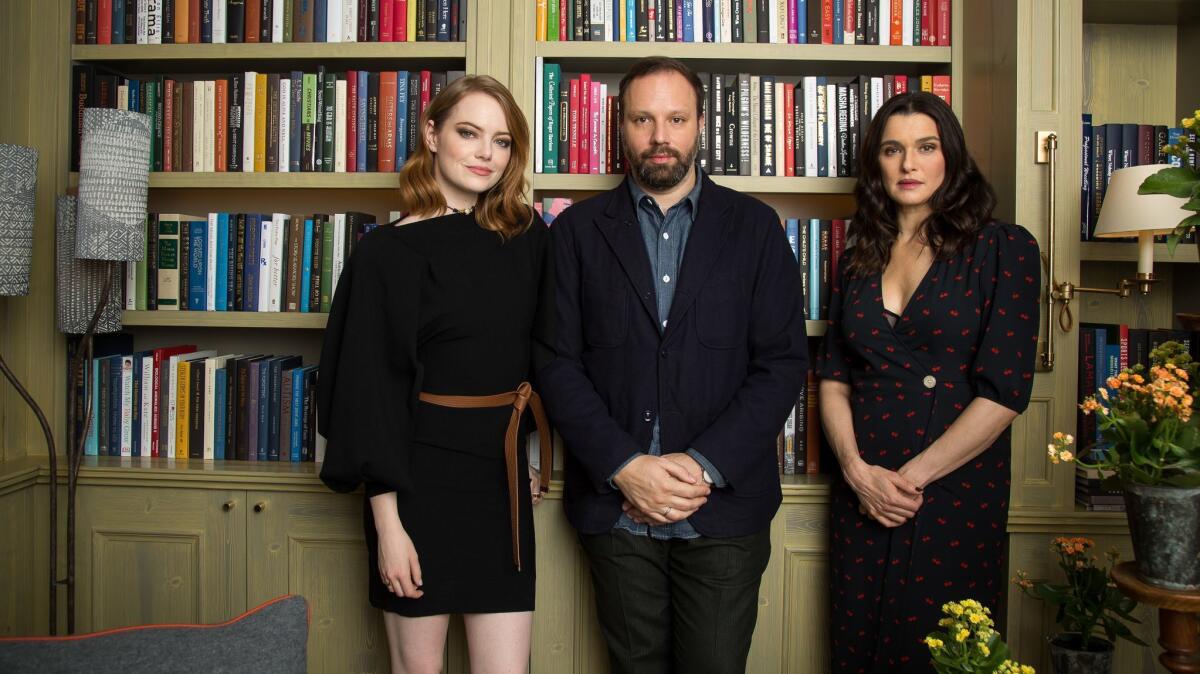 Actresses Emma Stone, left, and Rachel Weisz, right, pose with "The Favourite" director Yorgos Lanthimos, center, at the Whitby Hotel on November 13, 2018 in New York City.