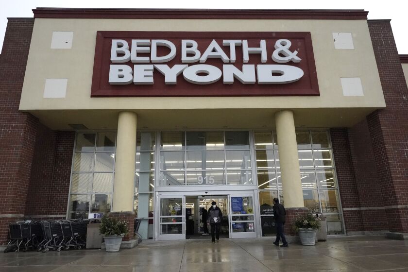 FILE - Shoppers enter and exit a Bed Bath & Beyond in Schaumburg, Ill., Jan. 14, 2021. Struggling Bed Bath & Beyond warned on Thursday that there's substantial doubt about the company's ability to continue as a "going concern" even as it continues to look at options like refinancing its debt or restructuring its business in bankruptcy court. (AP Photo/Nam Y. Huh, File)