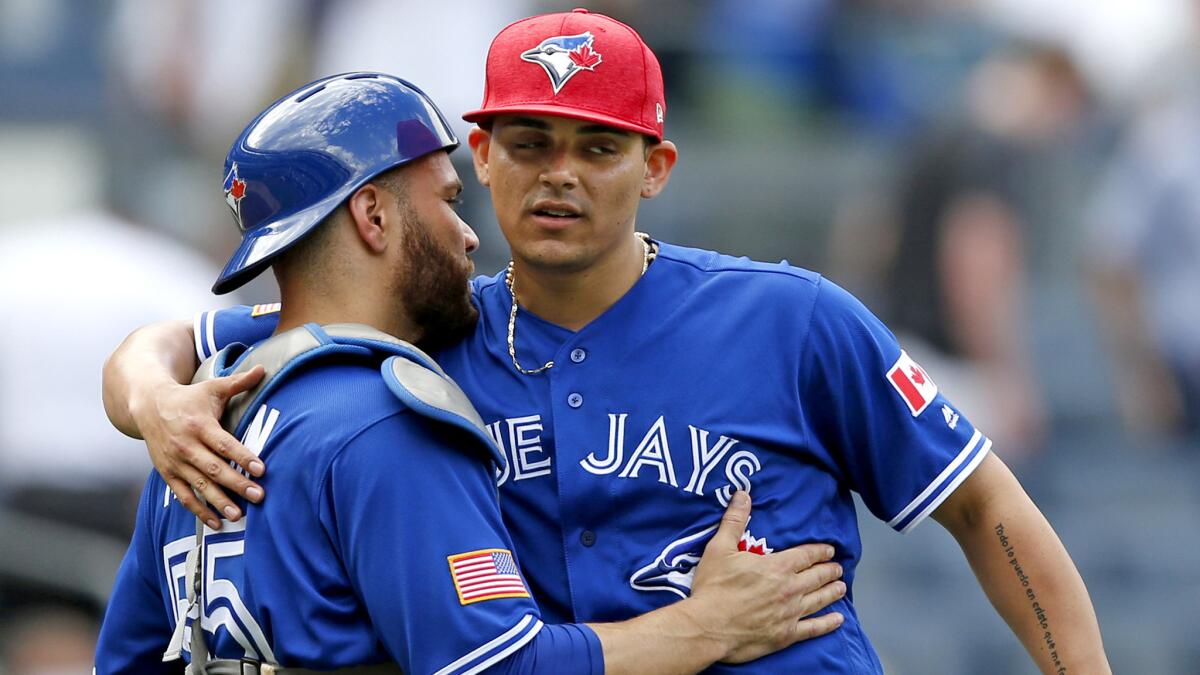 Blue Jays closer Roberto Osuna celebrates with catcher Russell Martin after a 4-1 victory over the Yankees earlier this season.