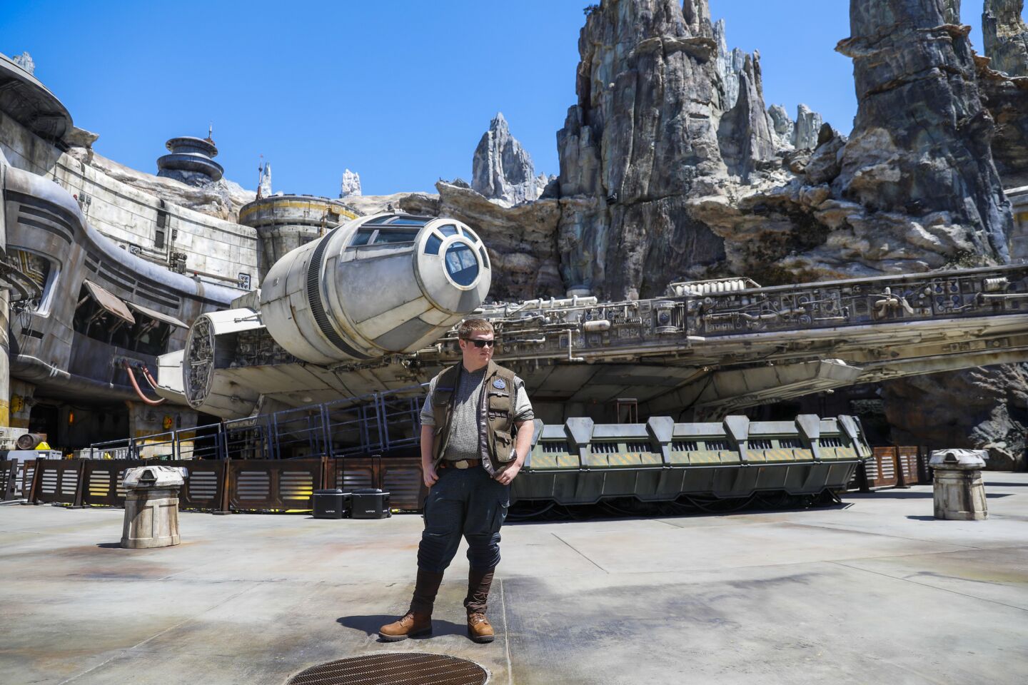 A Disney cast member stands in front of The Millennium Falcon: Smugglers Run ride inside Star Wars: Galaxy's Edge.