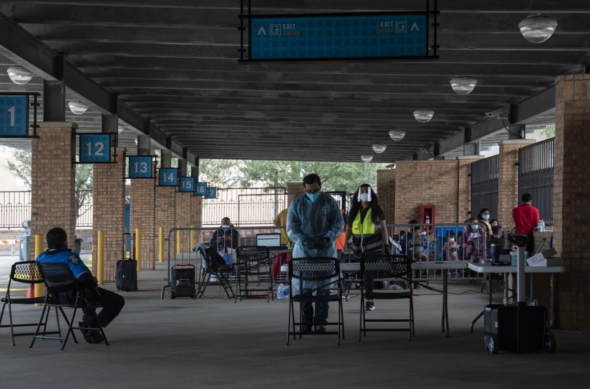 Police officers monitor an area reserved for asylum seekers as they wait to board their buses.