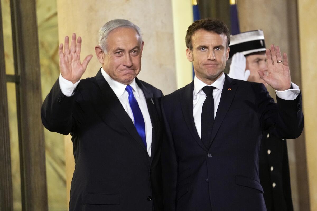 French president Emmanuel Macron, right, welcomes Israeli Prime Minister Benjamin Netanyahu prior to their meeting at the Elysee Palace, in Paris, France, Thursday, Feb. 2, 2023. Netanyahu is meeting France's president amid one of the deadliest periods of the Israeli-Palestinian conflict in years. Macron's office says he will share France's solidarity with Israel but also urge against action that would feed the spiral of violence.(AP Photo/Michel Euler)