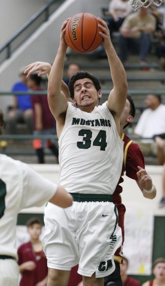 Costa Mesa's Julio Chavez pulls in a rebound during Thursday's basketball game against Estancia.