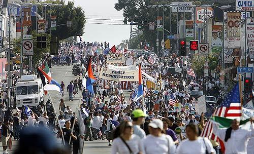 People taking part in the second of two immigration rights rallies walk down Alvarado Street.