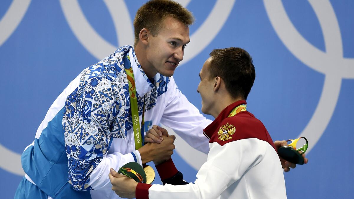 Kazakhstan's Dmitriy Balandin, left, is congratulated by bronze medalist Anton Chupkov of Russia on the podium after the men's 200-meter breaststroke final Wednesday.