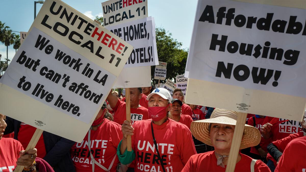 People in red shirts, holding signs calling for affordable housing in Los Angeles