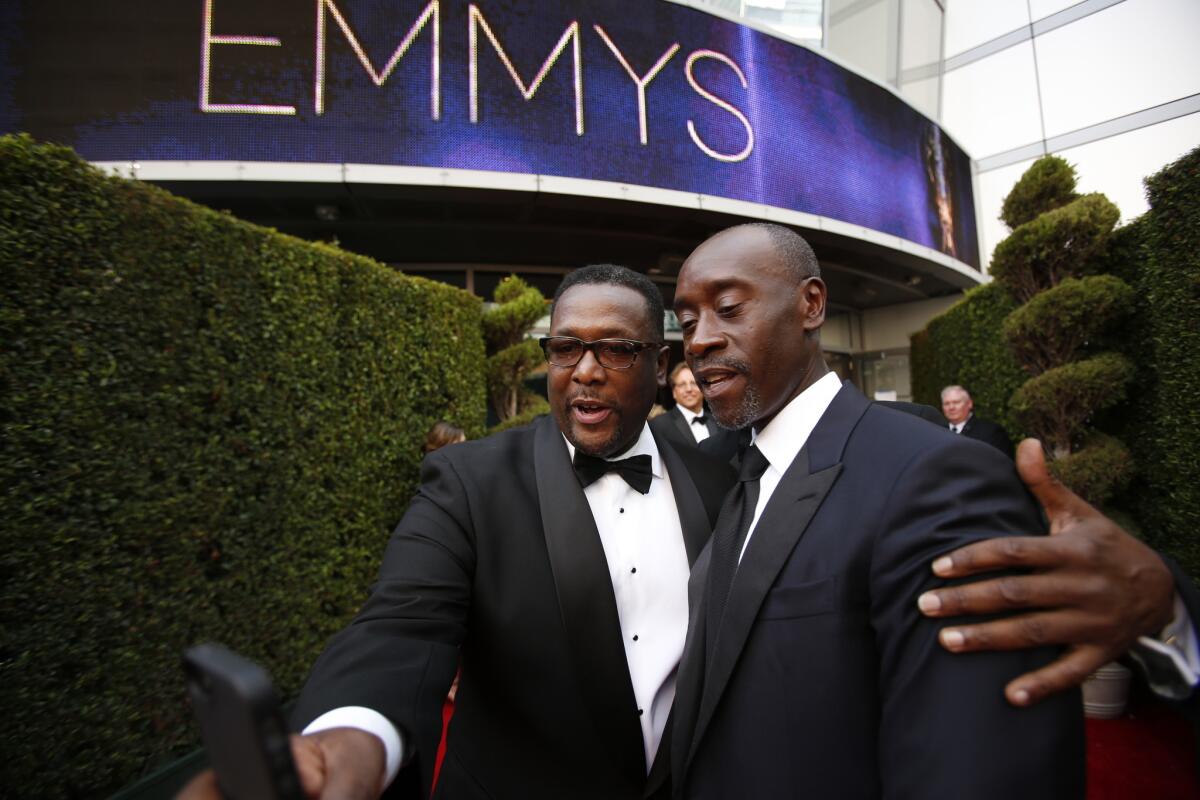 Wendell Pierce, left, arrives with Don Cheadle at the Emmy Awards at the Nokia Theatre on Aug. 25, 2014.