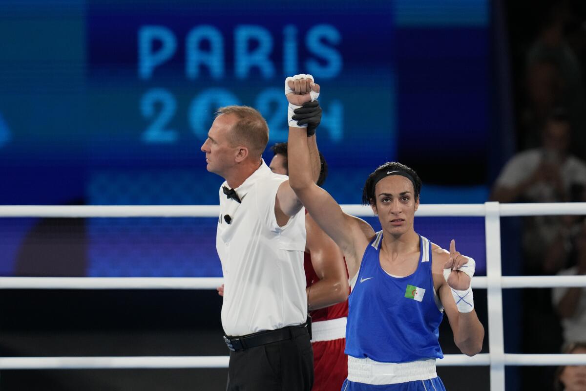 Algeria's Imane Khelif holds up one finger and points after defeating Thailand's Janjaem Suwannapheng in their match