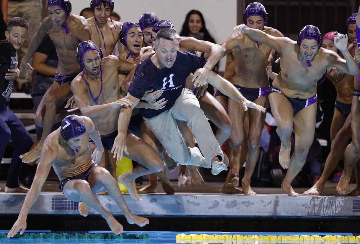 Hoover High boys' water polo coach Kevin Witt is dunked into the pool by his team after defeating Arcadia in the Pacific League Tournament championship match Thursday.