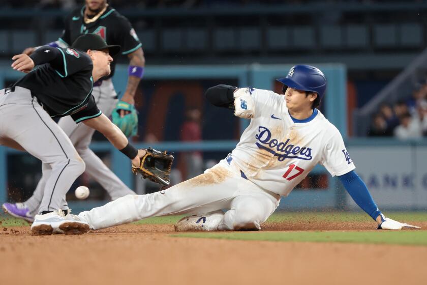 LOS ANGELES, CALIFORNIA May 21, 2024-Dodgers Shohei Ohtani steals second base as Diamondbacks shortstop Kevin Newman can't handle the throw in the sixth inning at Dodgers Stadium Tuesday. (Wally Skalij/Los Angeles Times)