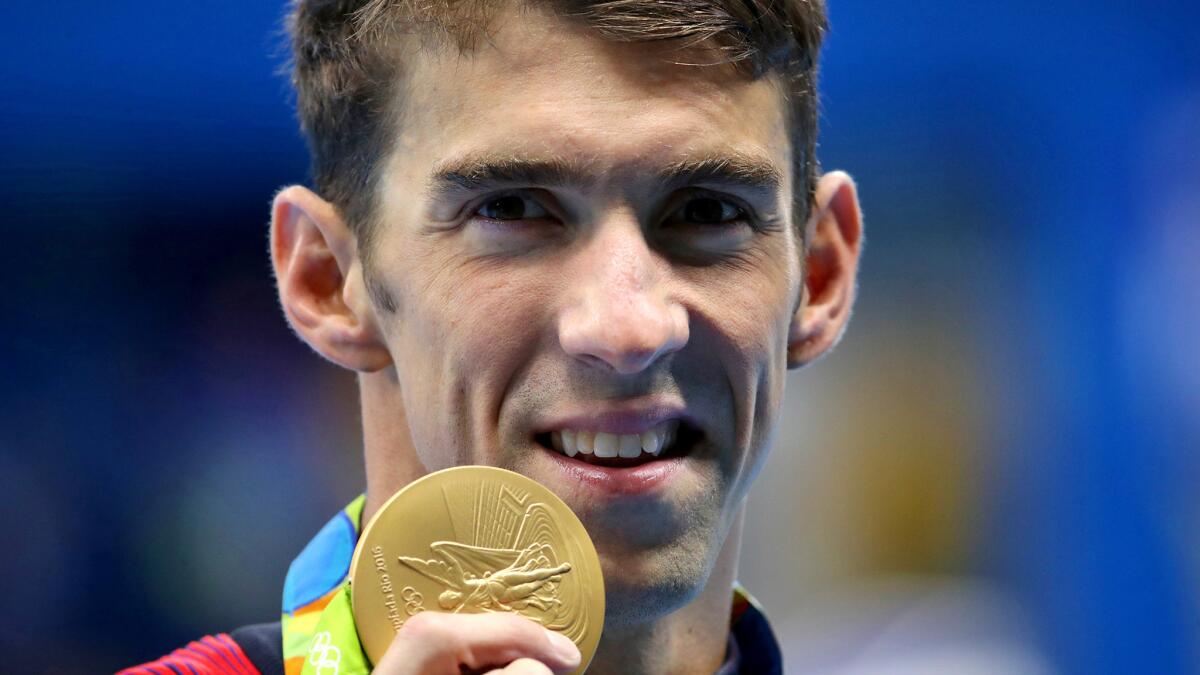 Michael Phelps shows off his fourth gold medal of the Rio Olympics on Thursday night after winning the 200-meter individual medley.