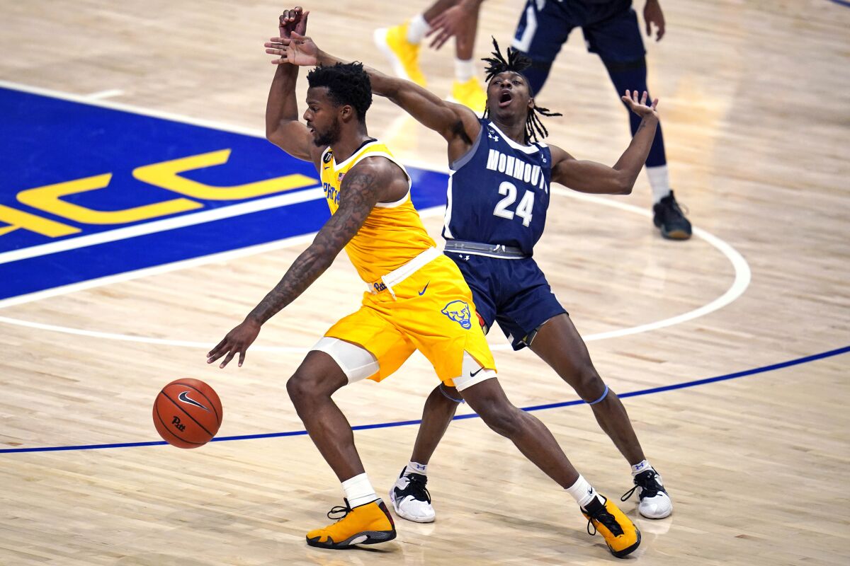 Pittsburgh guard Femi Odukale, left, is fouled by Monmouth guard Myles Ruth (24) during the first half of an NCAA college basketball game in Pittsburgh, Sunday, Dec. 12, 2021. (AP Photo/Gene J. Puskar)