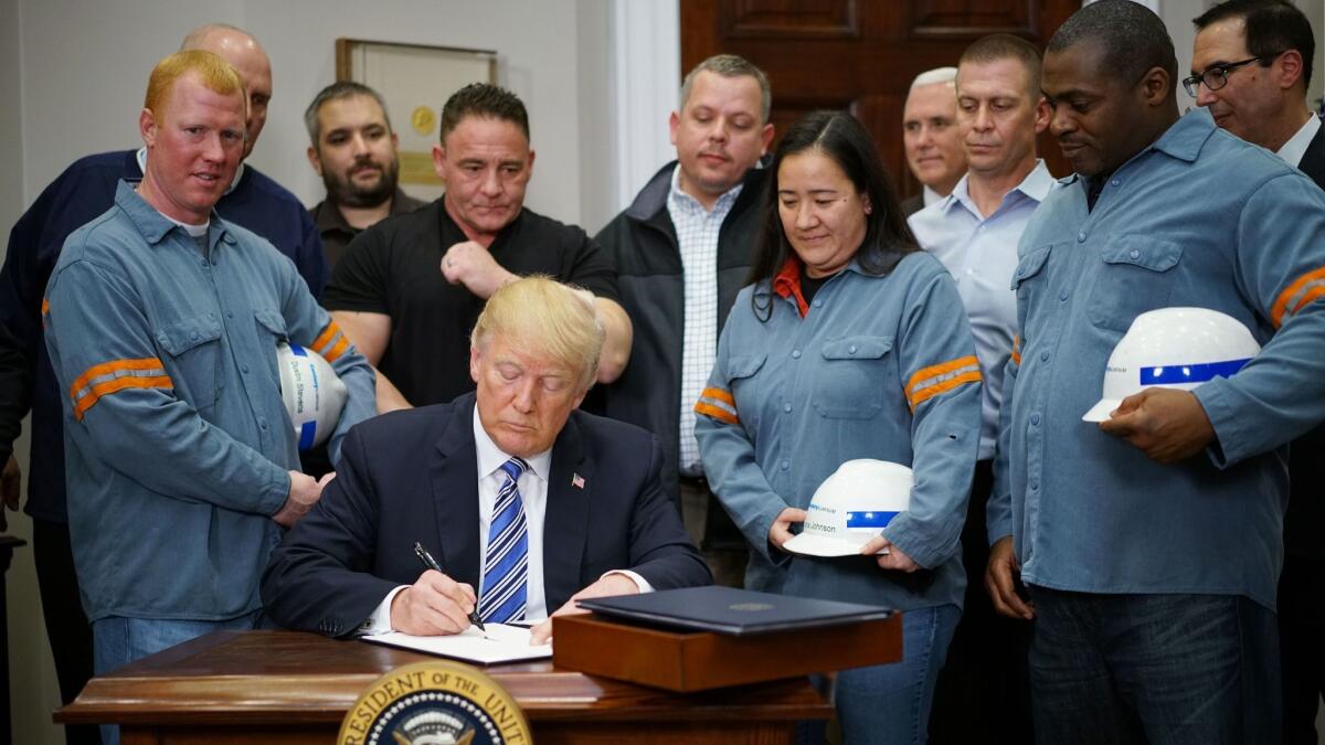 President Trump signs an executive order levying tariffs on imported steel and aluminum at the White House on March 8.