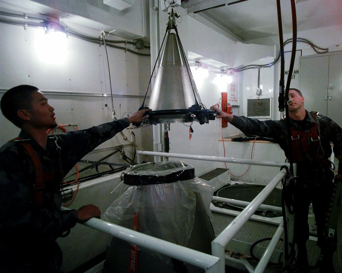 Airmen mount a refurbished nuclear warhead atop a Minuteman III ICBM in 1997