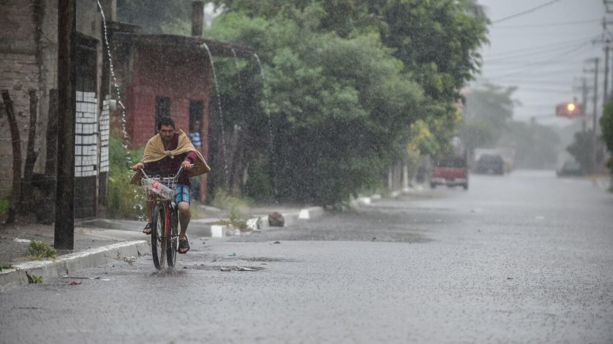 A resident rides his bike along a flooded street in Escuinapa, Sinaloa state, as Hurricane Willa headed toward Mexico's Pacific coast,