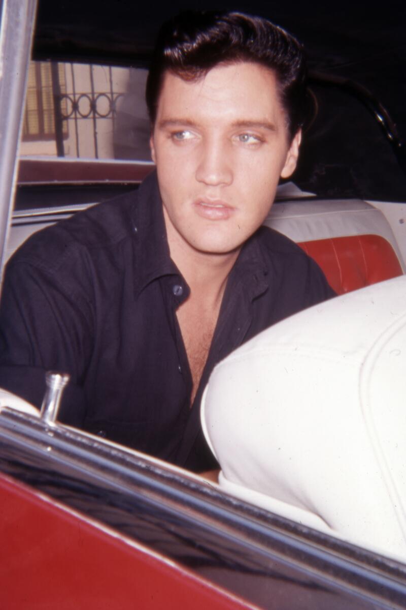 Elvis Presley sits in the backseat of his car as he leaves a movie studio lot. The date handwritten on the slide is June 7, 1962. (Photograph by Jon Verzi) (ONE TIME USE)