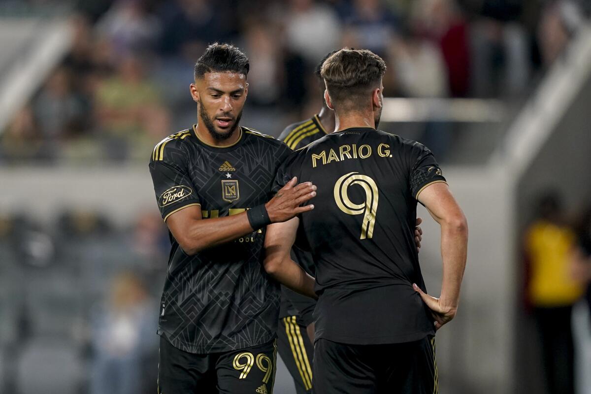 LAFC forward Denis Bouanga greets forward Mario González during the second half of LAFC's win over Vancouver.