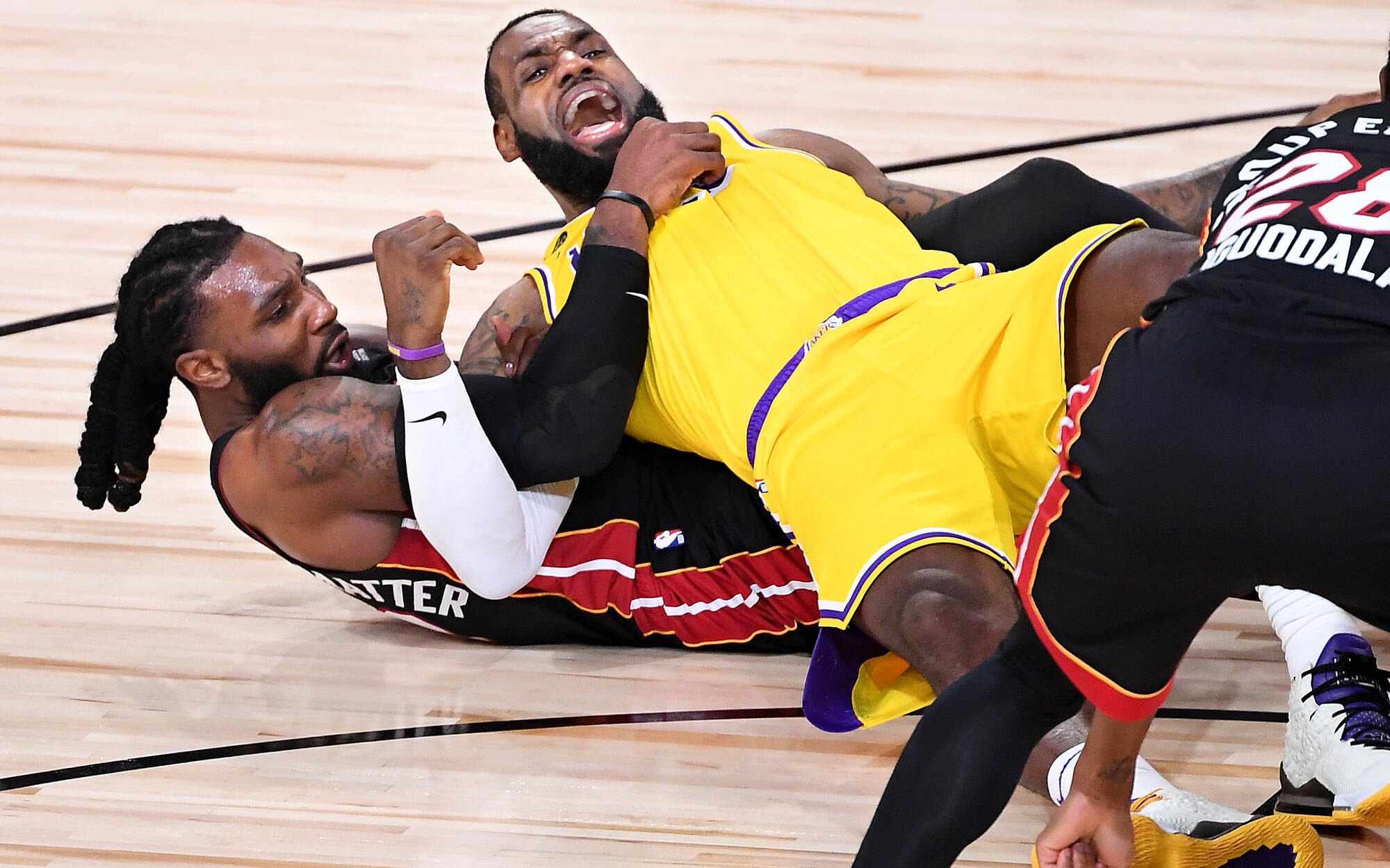 Lakers forward LeBron James falls to the court in a tangle with Heat forward Jae Crowder during Game 1.
