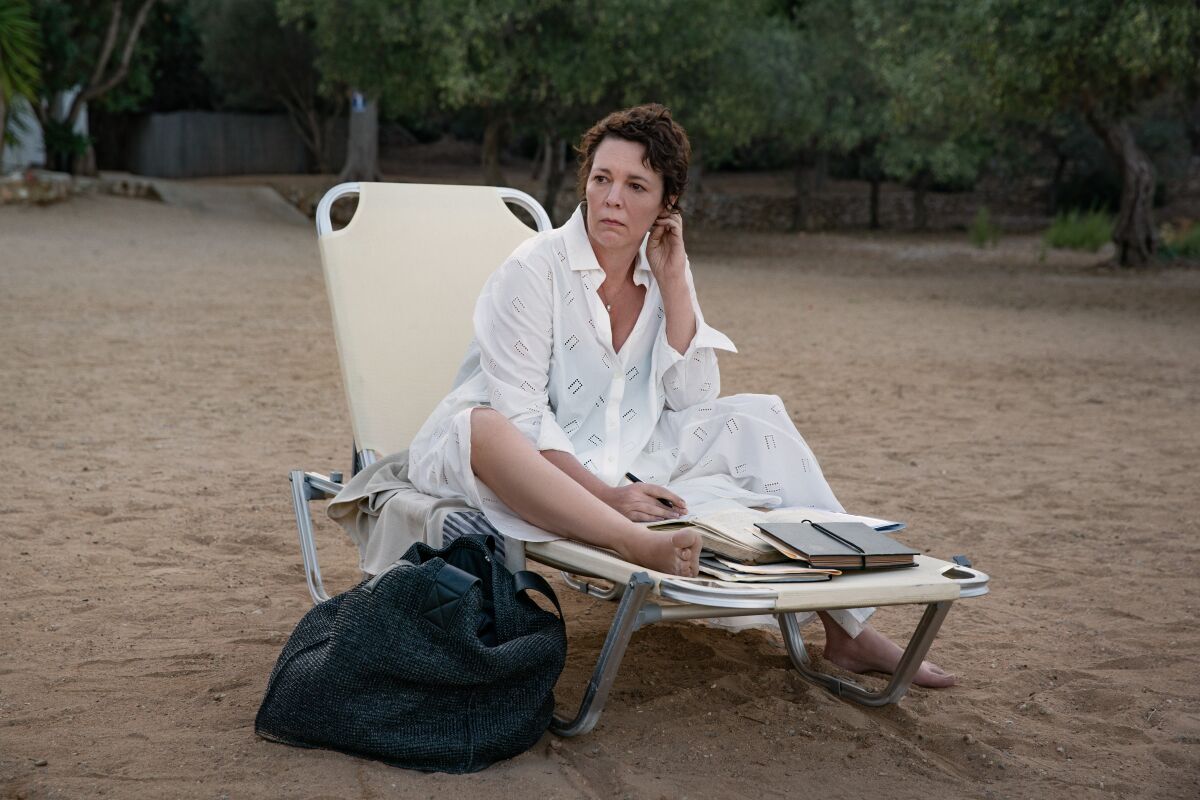Olivia Colman sitting in a lounge chair on the beach
