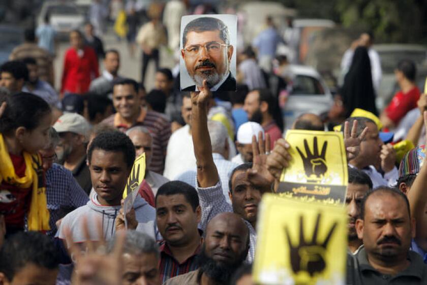 Supporters of Egypt's Mohamed Morsi raise the ousted president's image at a protest last week in Cairo.