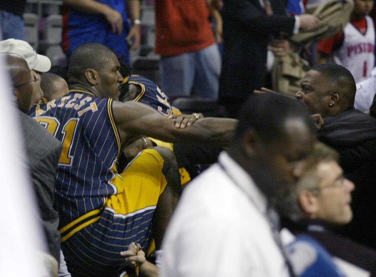 Indiana Pacers forward Ron Artest climbs into the stands during a brawl at an NBA game against the Detroit Pistons on Nov. 19, 2004, in Auburn Hills, Mich.