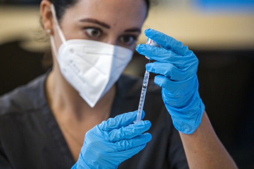 Nursing student Brittany Corlyn draws vaccine medicine into a syringe.