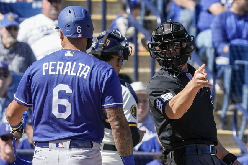 Home plate umpire Jim Wolf tells Los Angeles Dodgers' David Peralta to take a base.