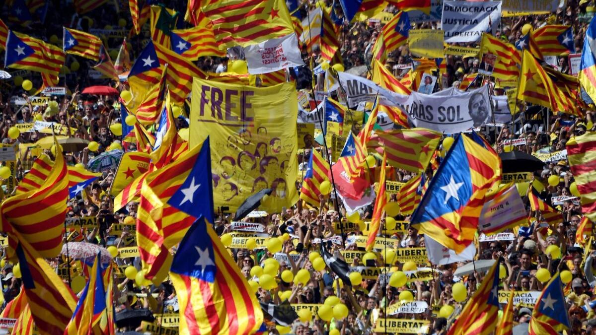 People wave Catalan pro-independence flags during a demonstration in Barcelona, Spain, to support jailed leaders and politicians on April 15, 2018.