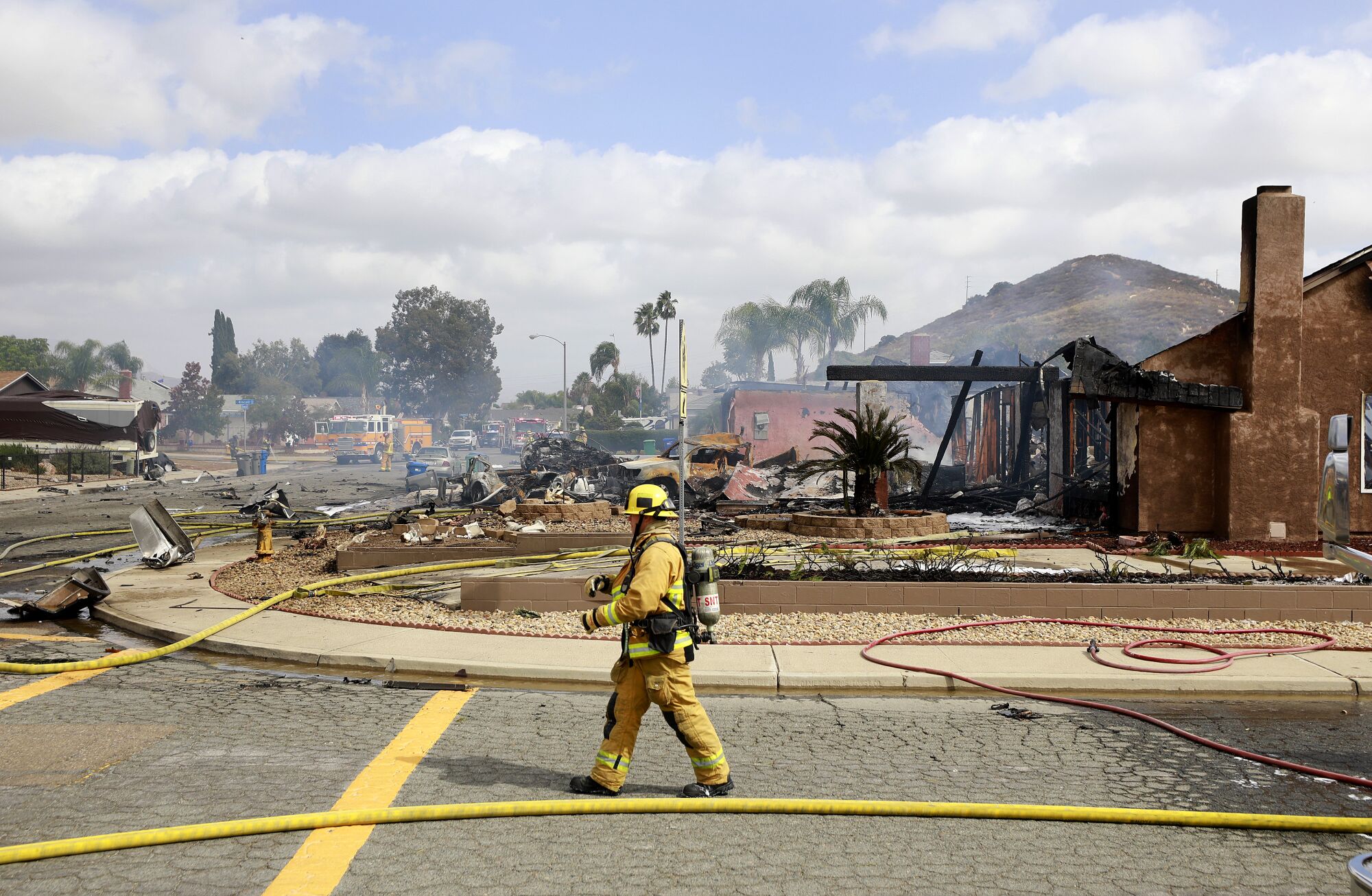 A firefighter walks by the scene of a fatal plane crash on Monday, Oct. 11, 2021 in Santee, CA. 