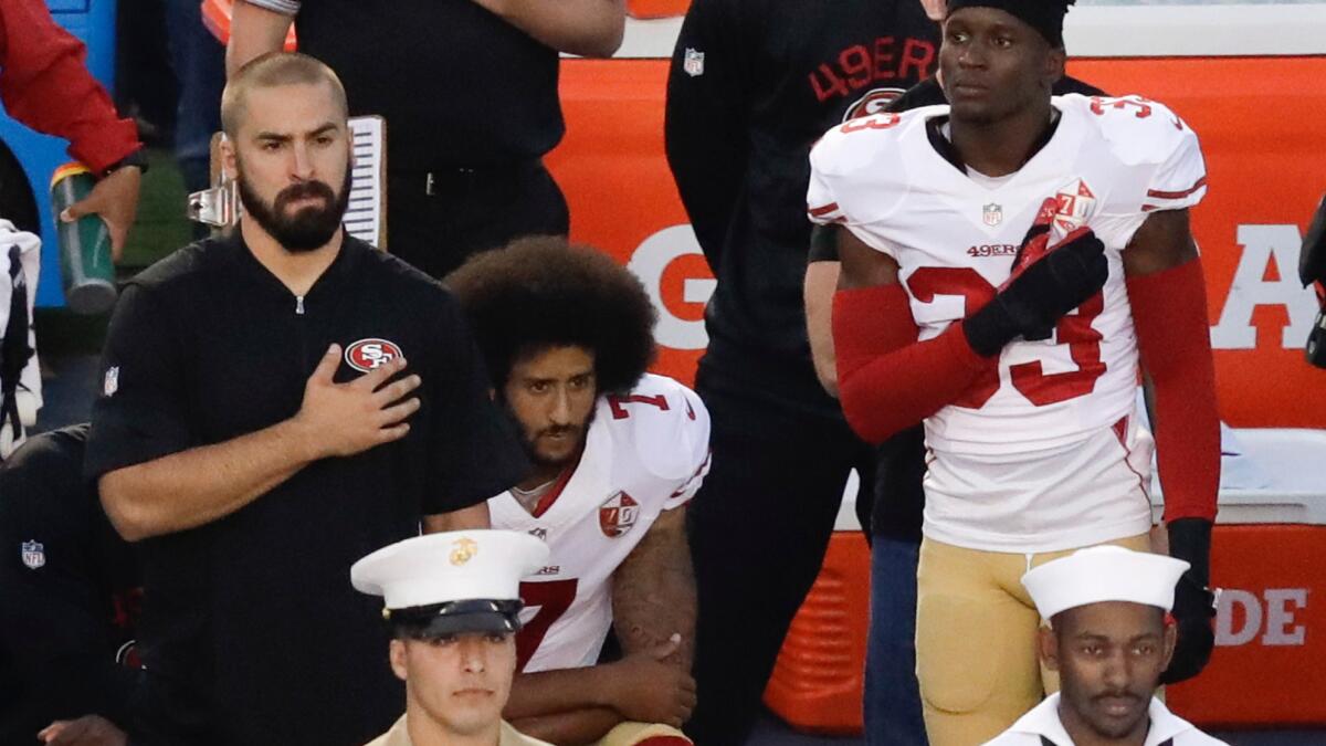 Then-San Francisco 49ers quarterback Colin Kaepernick, middle, takes a knee during the national anthem before a preseason game against San Diego on Sept. 1, 2016.