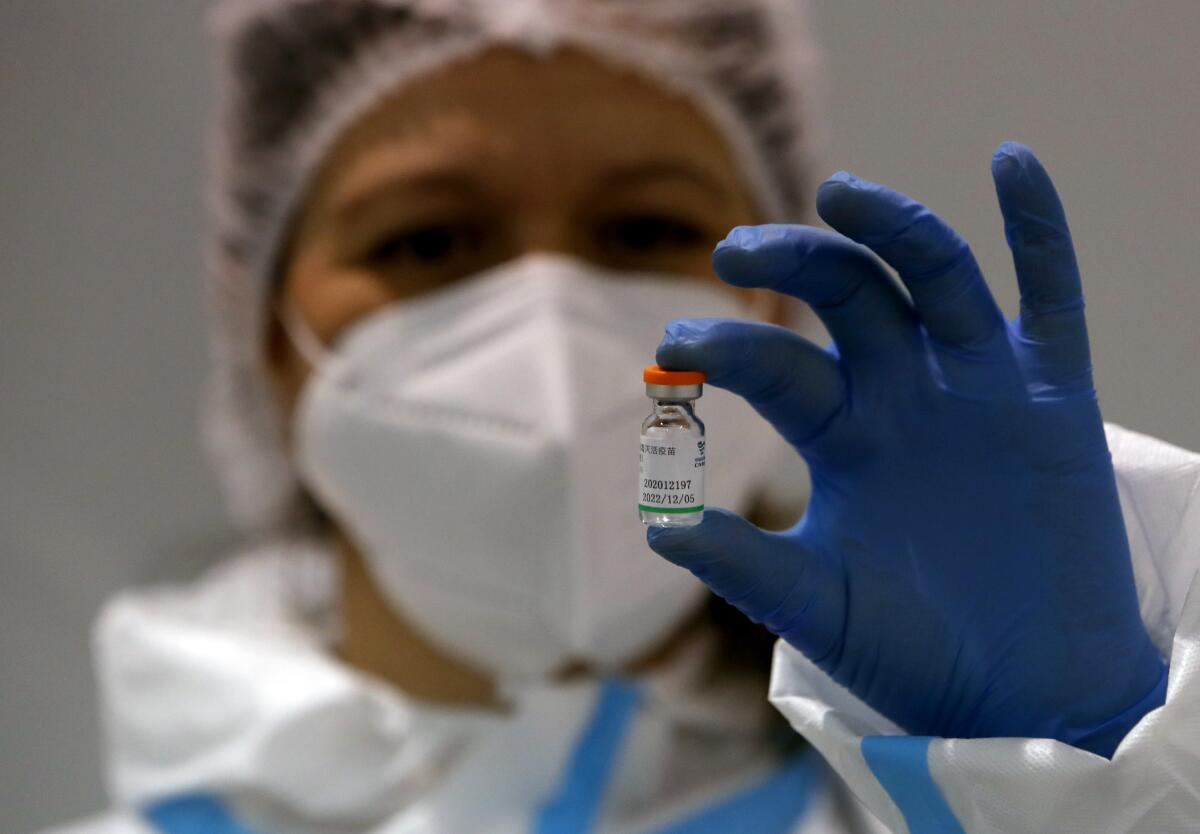 una trabajadora de salud mostrando un frasco con la vacuna de Sinopharm contra el COVID-19 en Belgrado, 