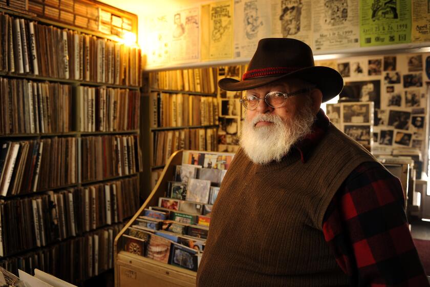 (Published 02/21/2010, G-1) Feb. 8, 2010 - Lou Curtiss, founder of Folk Arts Rare Records and the San Diego Folk Festival stands among the thousands of records in his Normal Heights store on Tuesday, Feb. 9, 2010. (Photo Credit: K.C. ALFRED/The San Diego Union-Tribune)