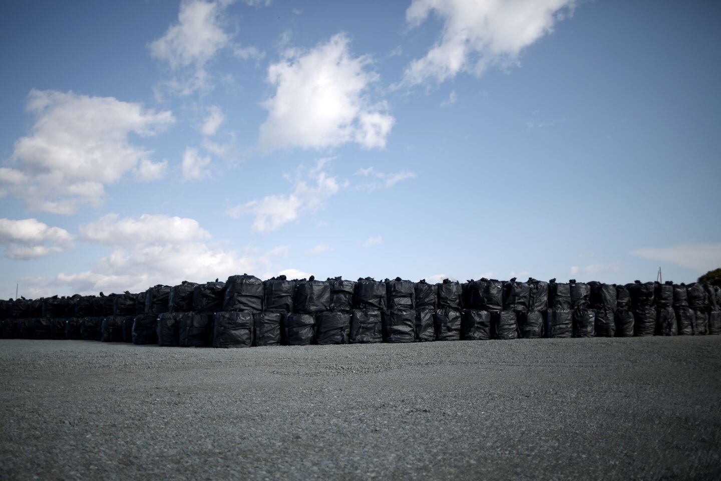 Thousands of bags of radiation-contaminated soil and debris wait to be processed in the town of Naraha.