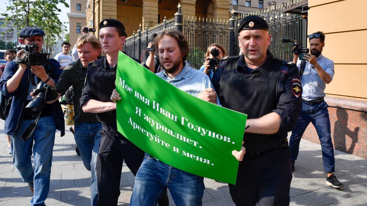 Police officers detain a man protesting the arrest of journalist Ivan Golunov outside the headquarters of the Moscow branch of the Russian Interior Ministry in Moscow on June 7.