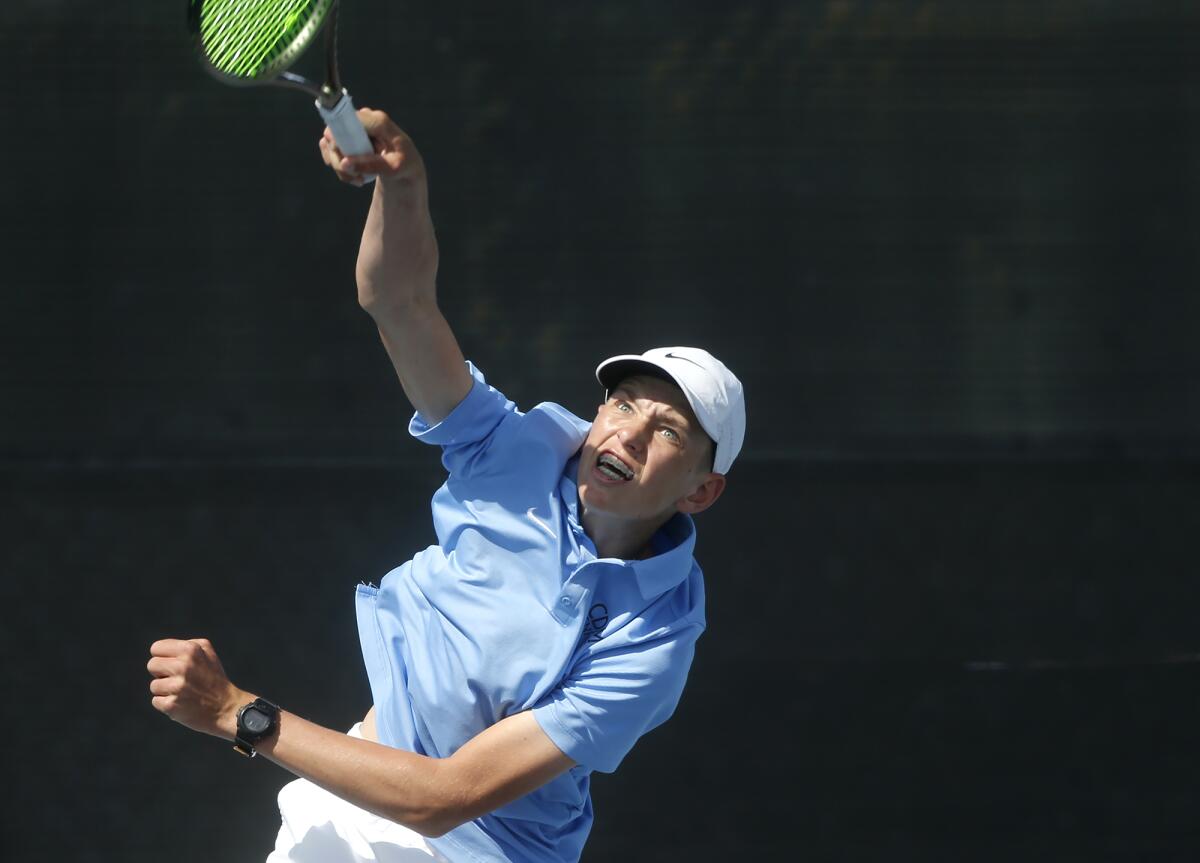 Ivan Pflueger of Corona del Mar rips a serve during a doubles match against Palos Verdes Peninsula on Wednesday.