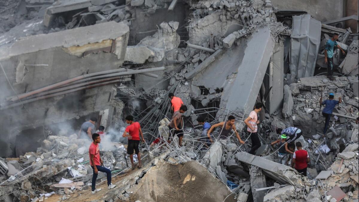 Palestinians inspect the al-Meshal building destroyed in Israeli air strike in the west of Gaza City in Gaza on Thursday.