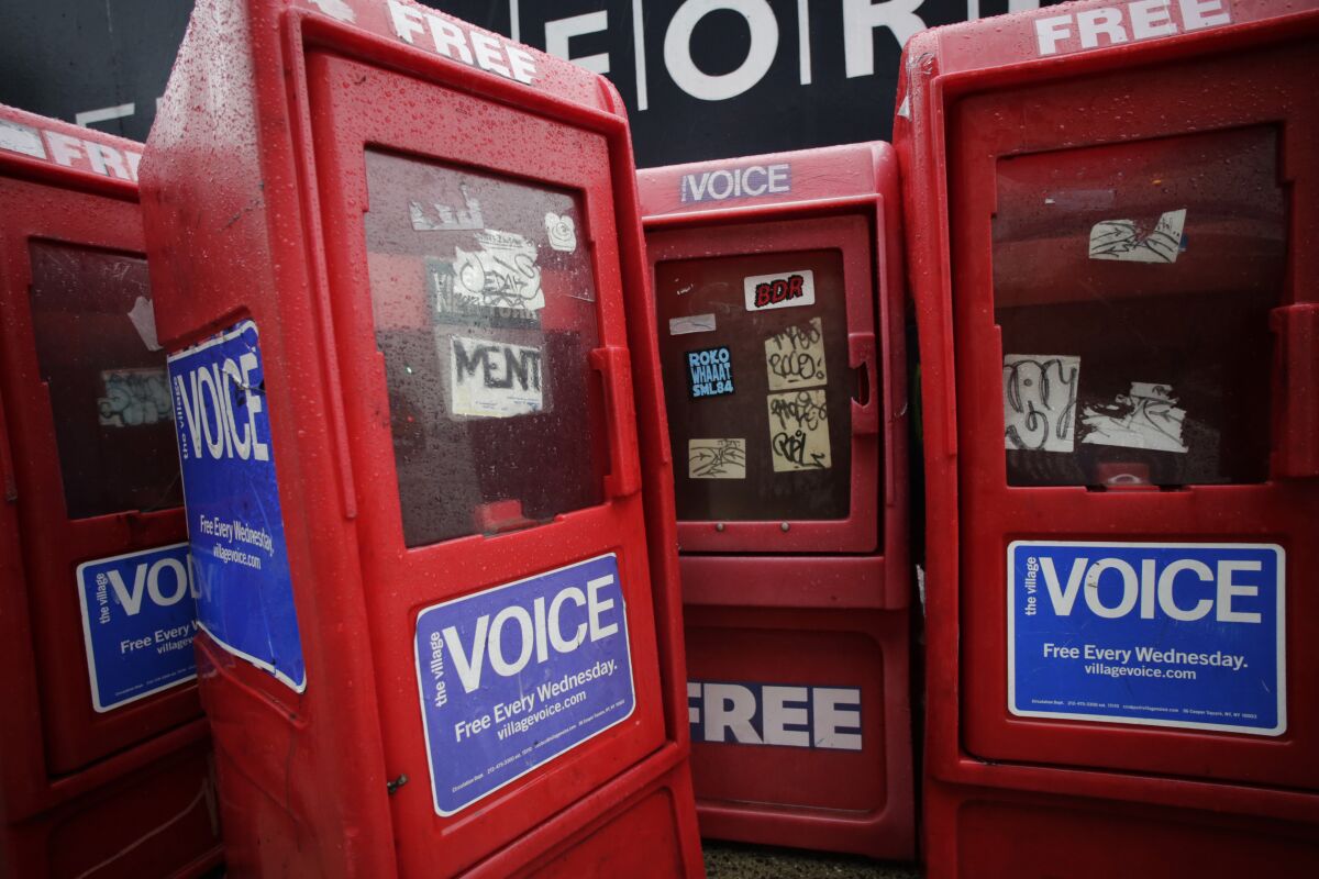 Plastic newspaper boxes for the Village Voice on a Manhattan sidewalk in 2013. 