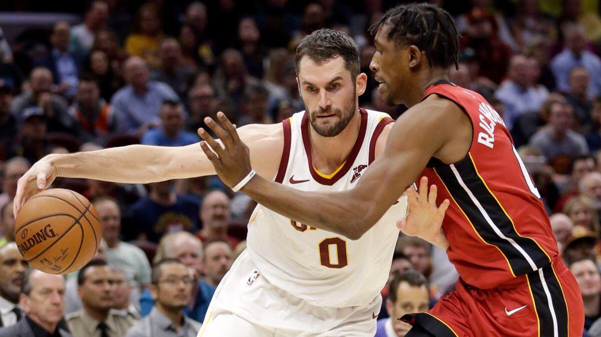 Cleveland Cavaliers' Kevin Love, left, drive past Miami Heat's Josh Richardson in the first half on Tuesday.