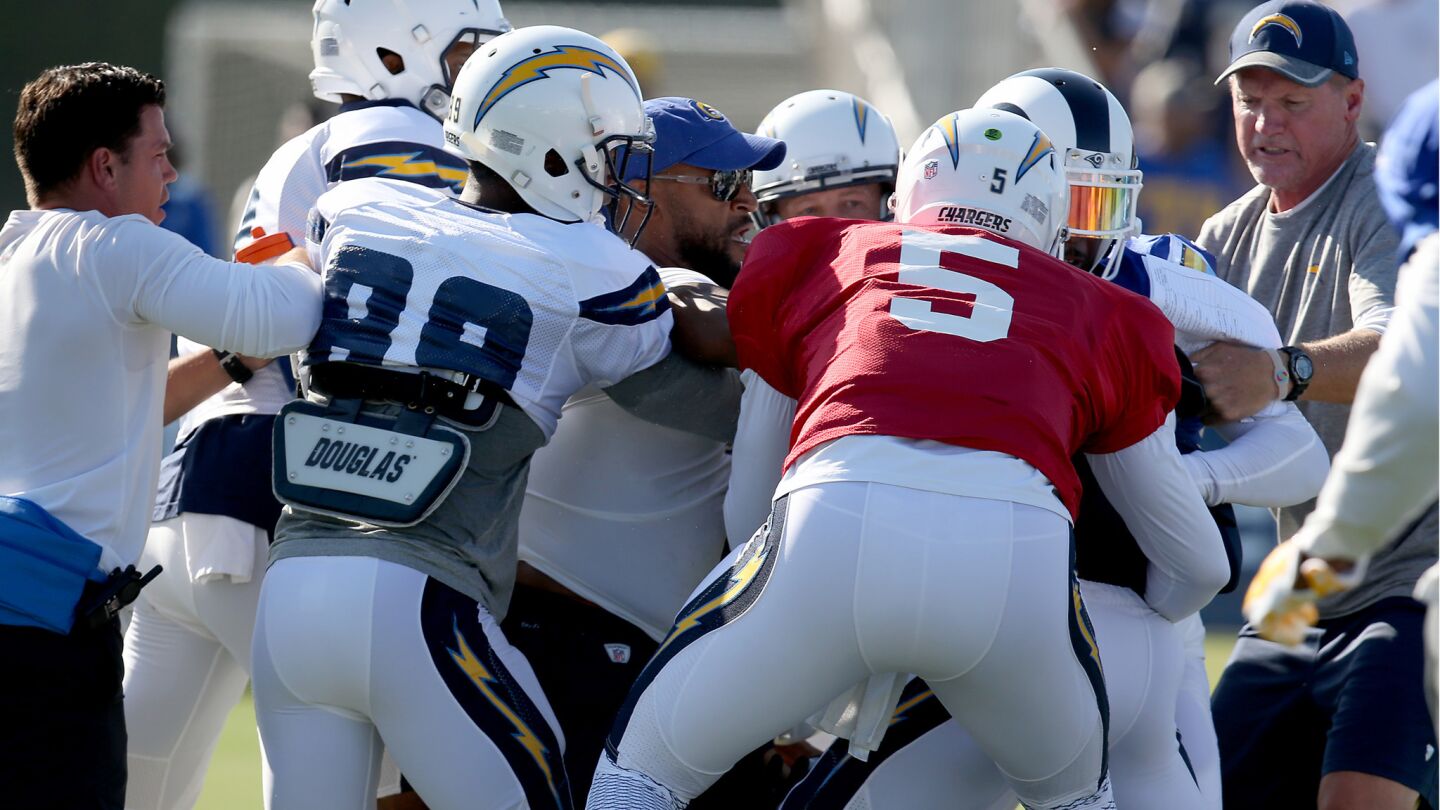Chargers and Rams players and coaches get into a tussle.