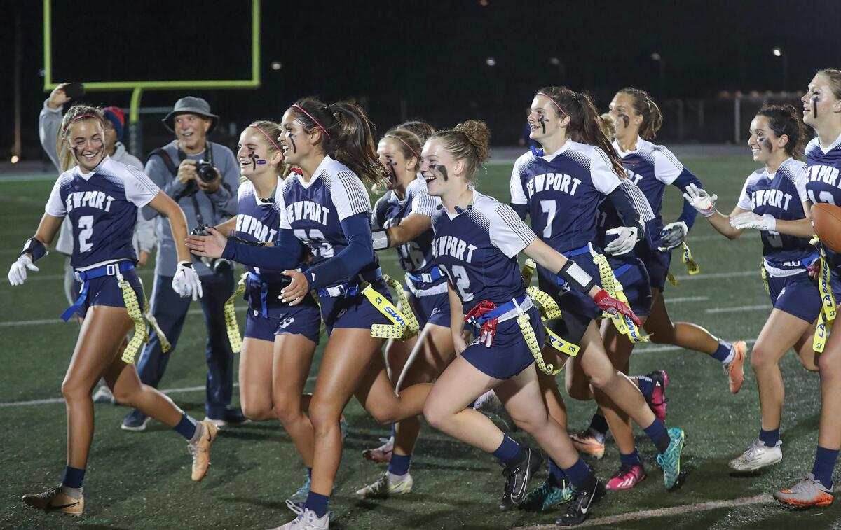 The Newport Harbor girls' flag football team celebrates its third win of the year over rival Corona del Mar.